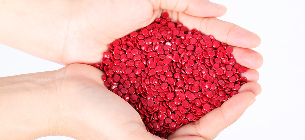 Hands holding a pile of red plastic material