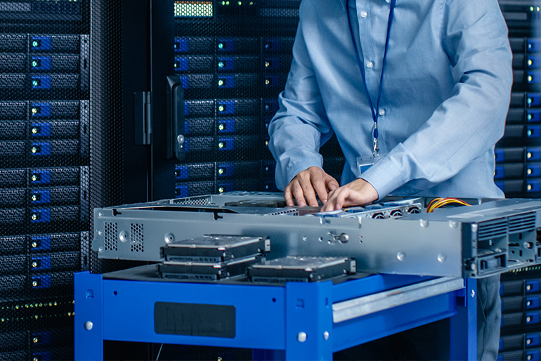 Person installing hardware into a server rack