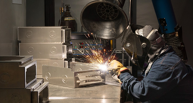 Person welding a small sheet metal enclosure